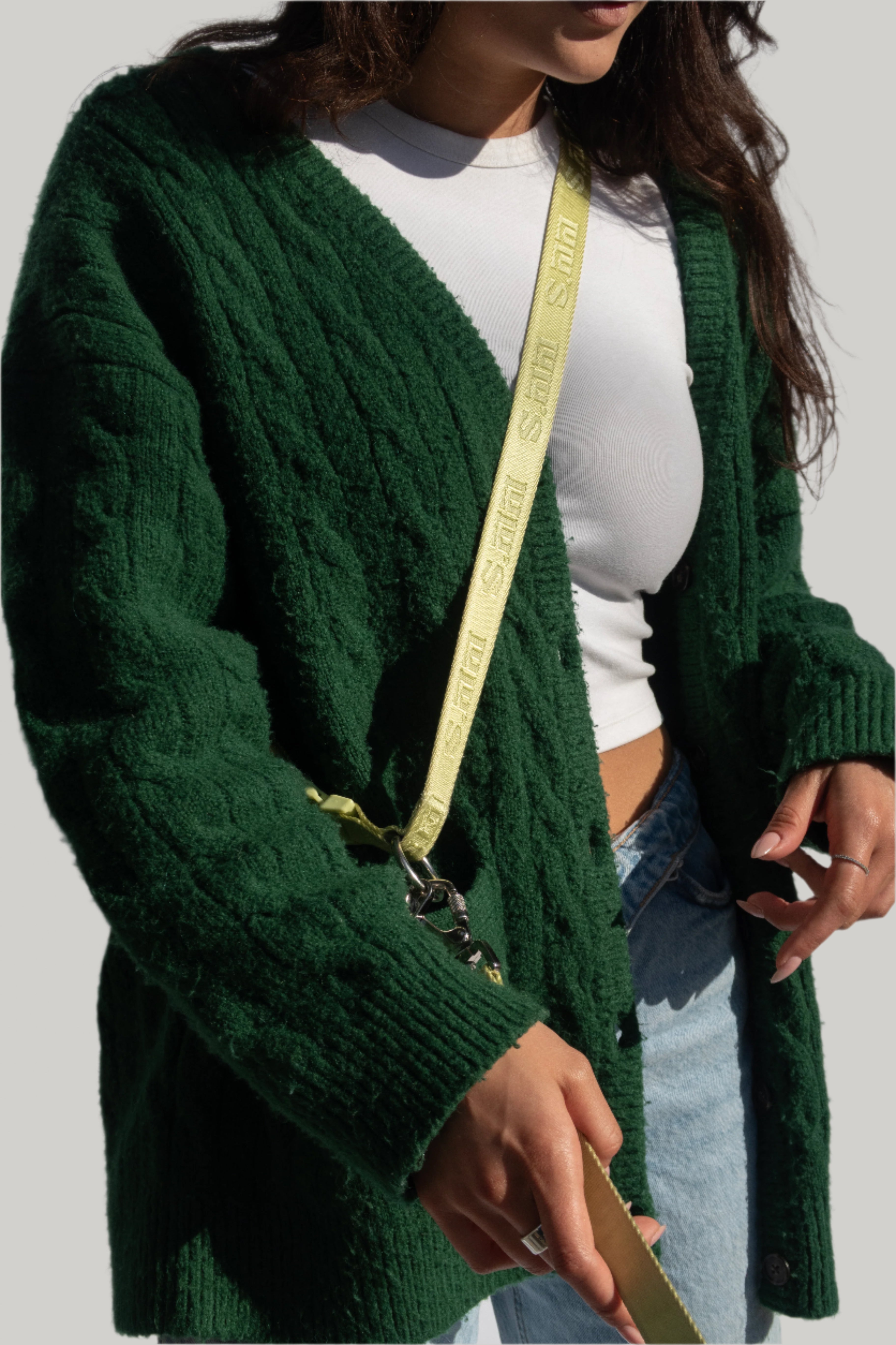 Model wearing green cardigan and white crop top, showcasing Lulu’s from Cali matcha green hands-free dog leash worn crossbody.