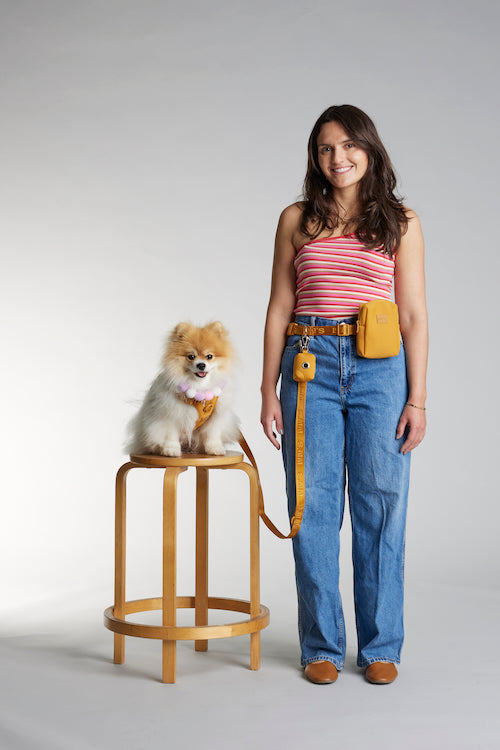 woman modeling hands-free dog leash set with waste bag pouch in sunburnt orange