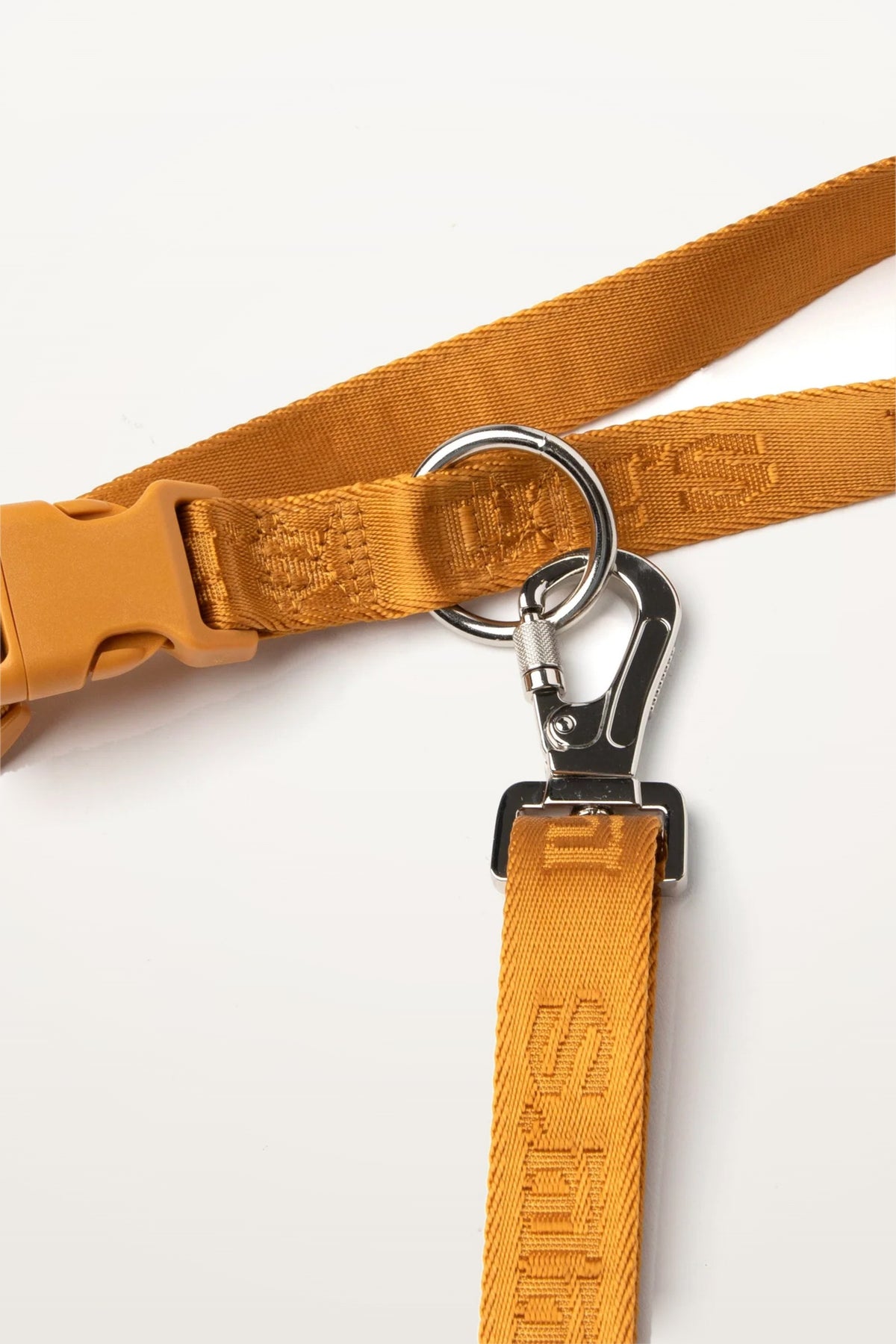 Close-up of a Sand Orange Lulu's from Cali leash with woven logo and silver clip