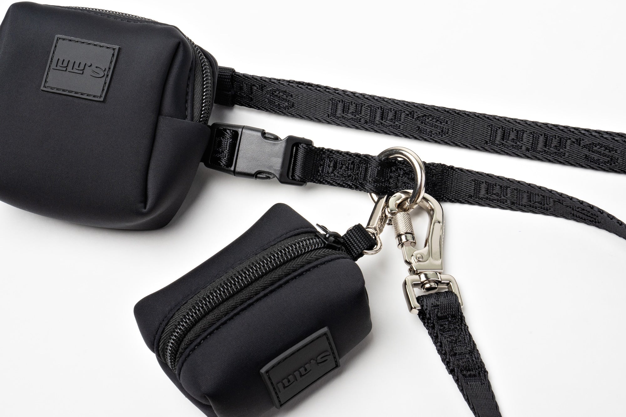 Close-up of Lulu's Midnight Black accessory set, featuring a sleek waste bag holder, treat pouch, and durable leash with secure attachments.