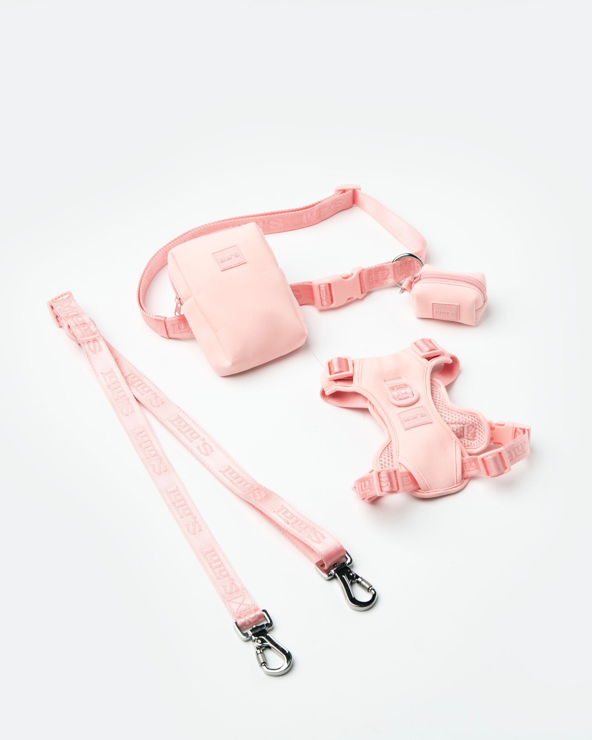 LULU's set in Blush pink, featuring a belt with an accessory pouch, a small poop bag holder, a harness, and a leash. The set showcases coordinated dog walking accessories designed for style and functionality.