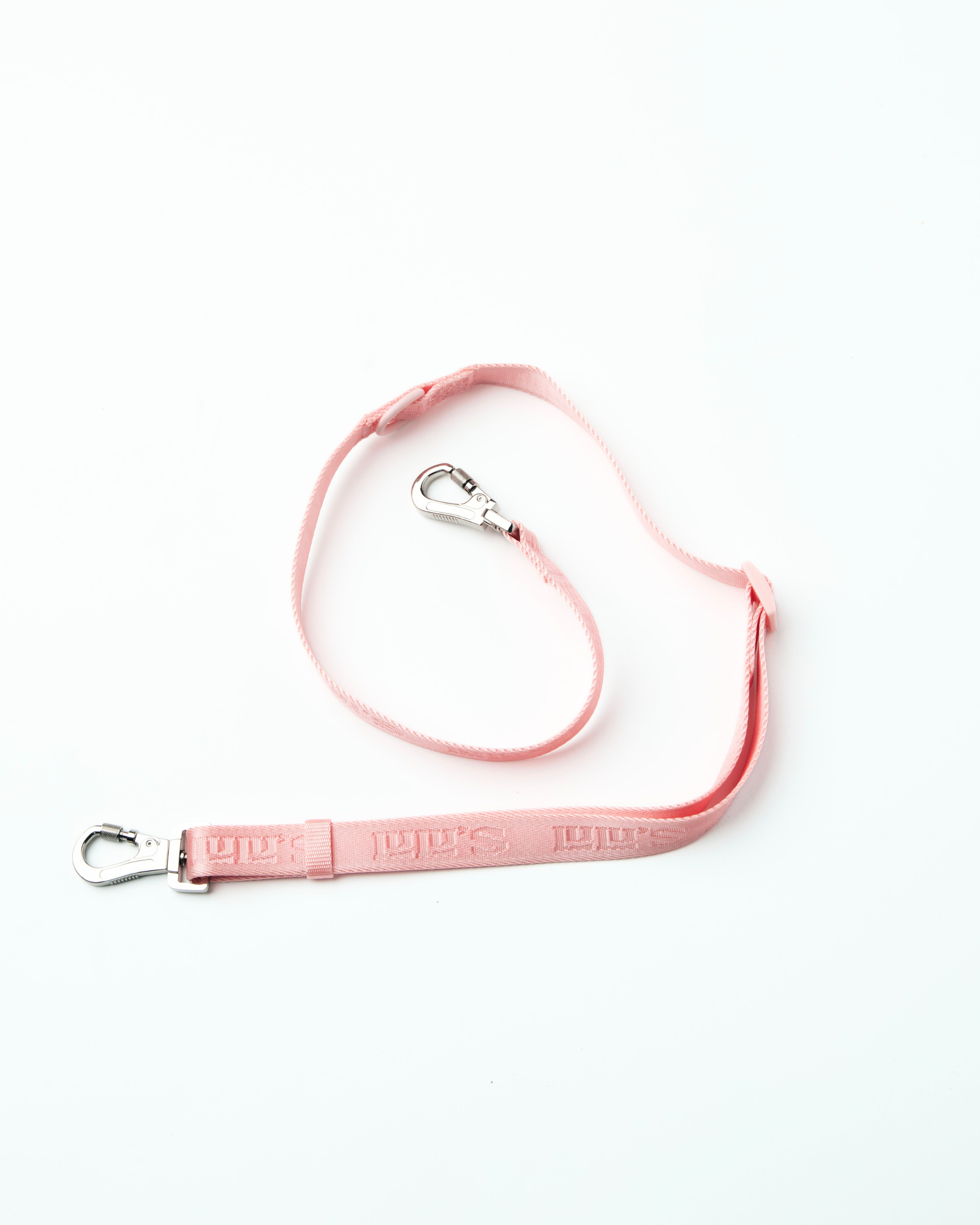 A Blush pink Lulu's adjustable dog leash with metal clips on both ends, featuring the brand's logo and a durable design, laid out flat.